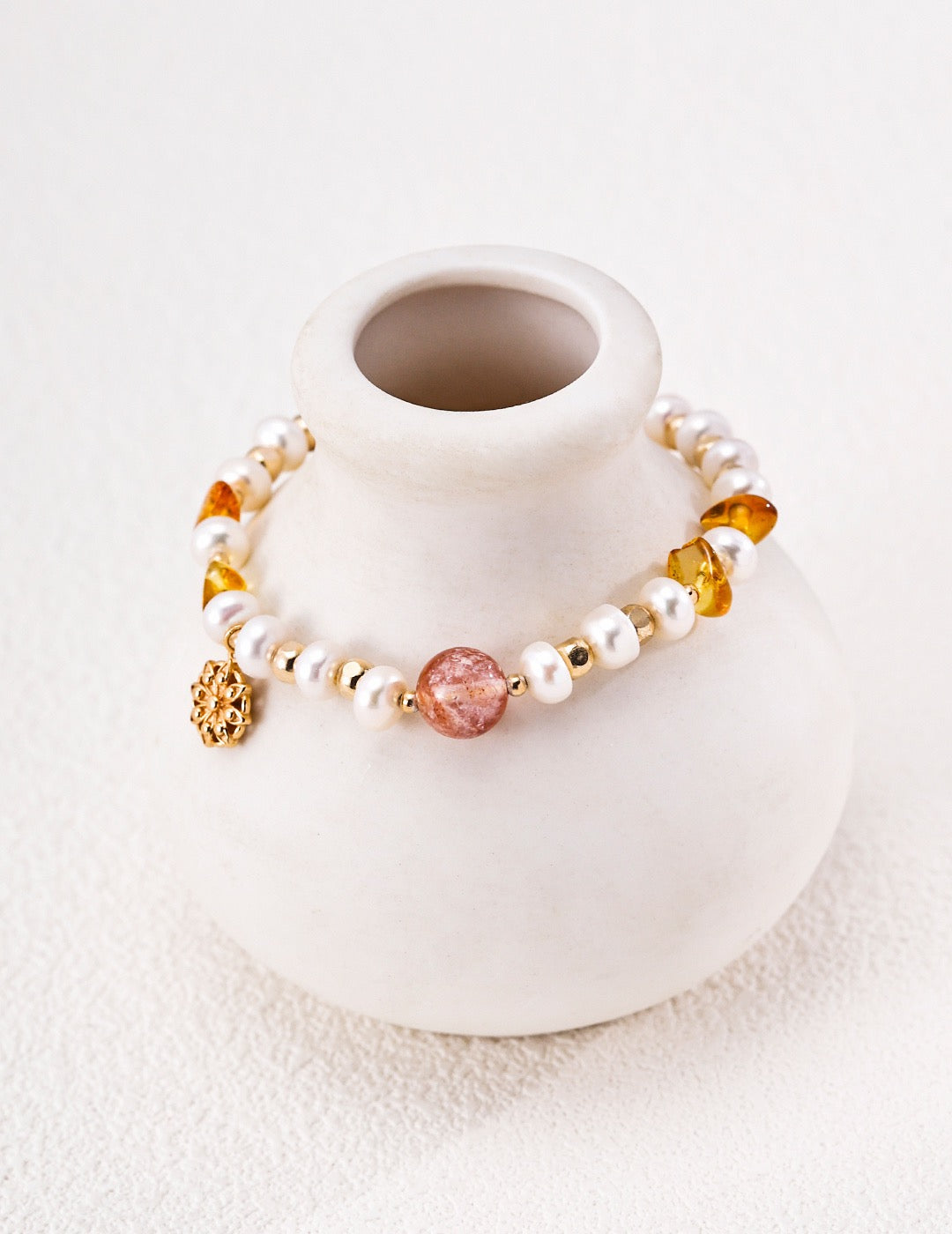 Solène pearl and crystal bracelet displayed around a ceramic vase